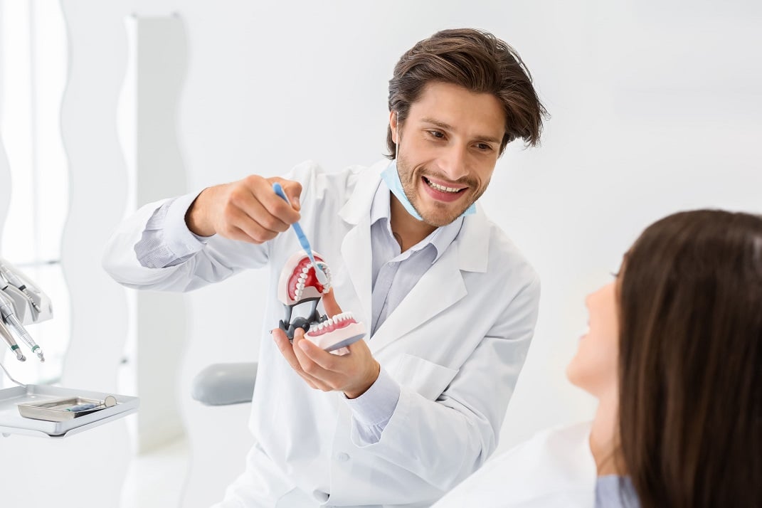 A dental professional showing proper brushing techniques